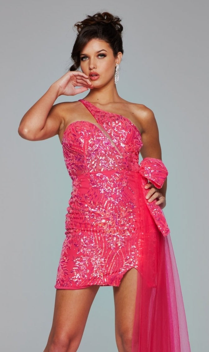A woman poses in the Jovani 39705 Side-Bow Short Sequin Hoco Dress, featuring a one-shoulder design with a sheer pink sash, against a plain gray background.